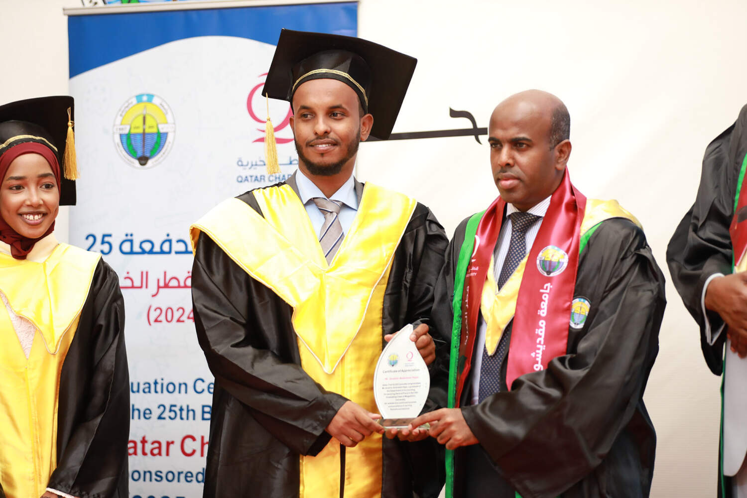 Graduates sponsored by Qatar Charity at the 25th batch graduation ceremony, one receiving an award